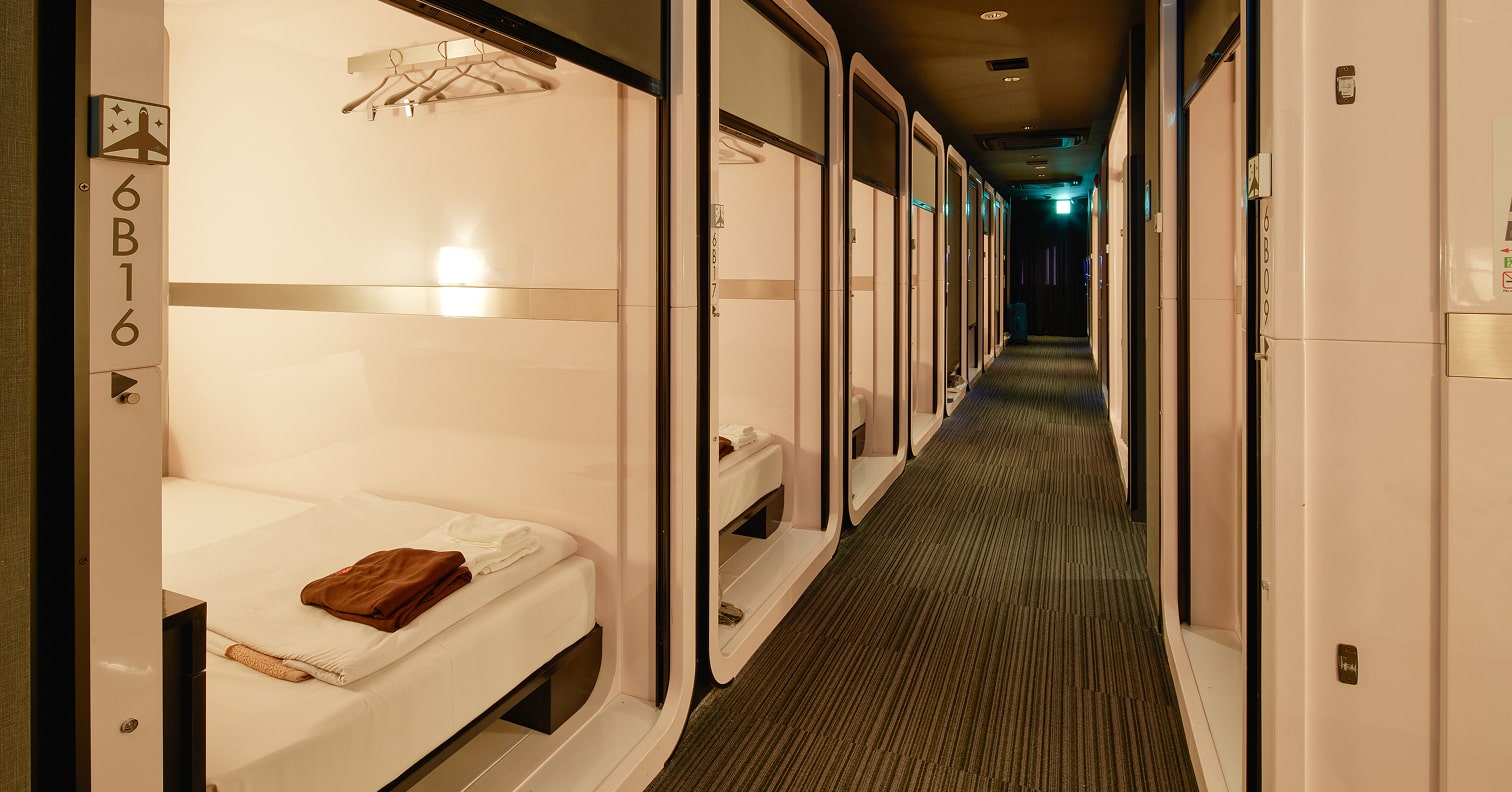 Row of ship-style sleeping cabins along a lit corridor