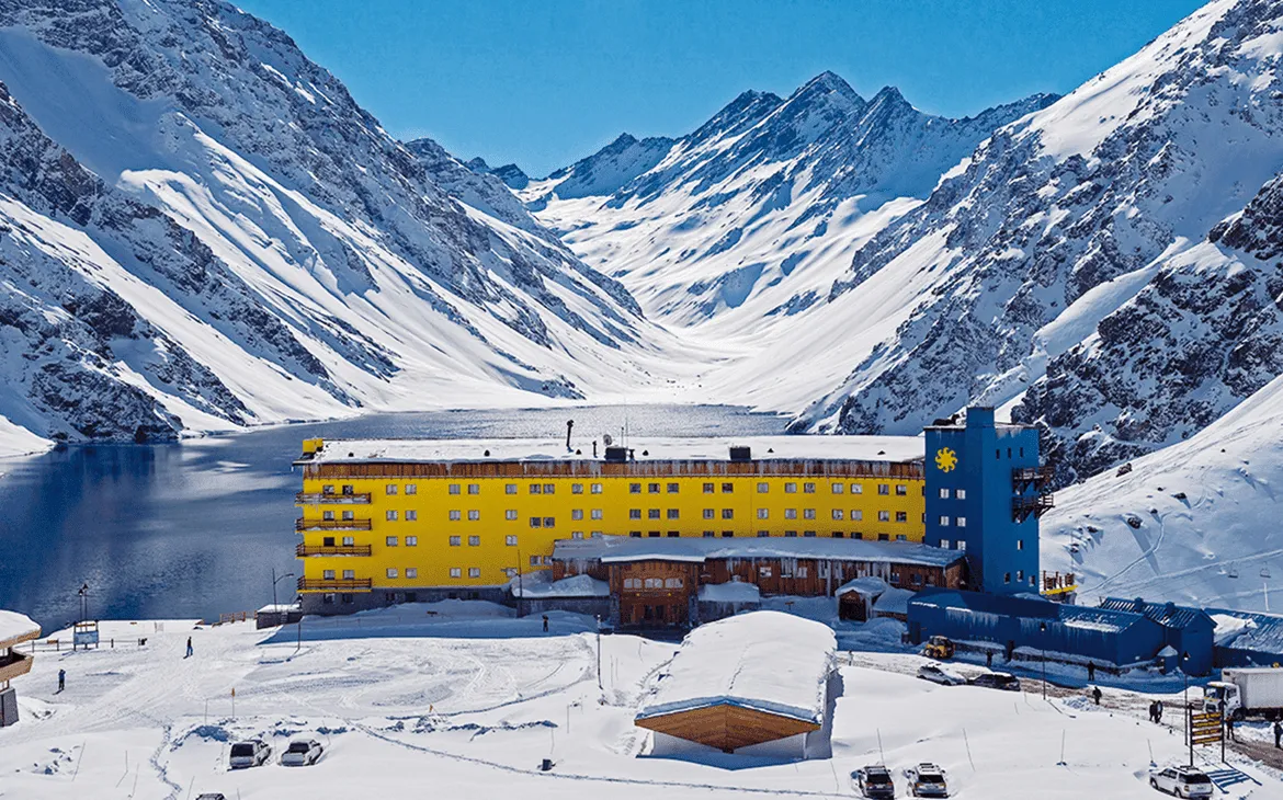 Isolated hotel building above a lake ringed by bare mountain rock